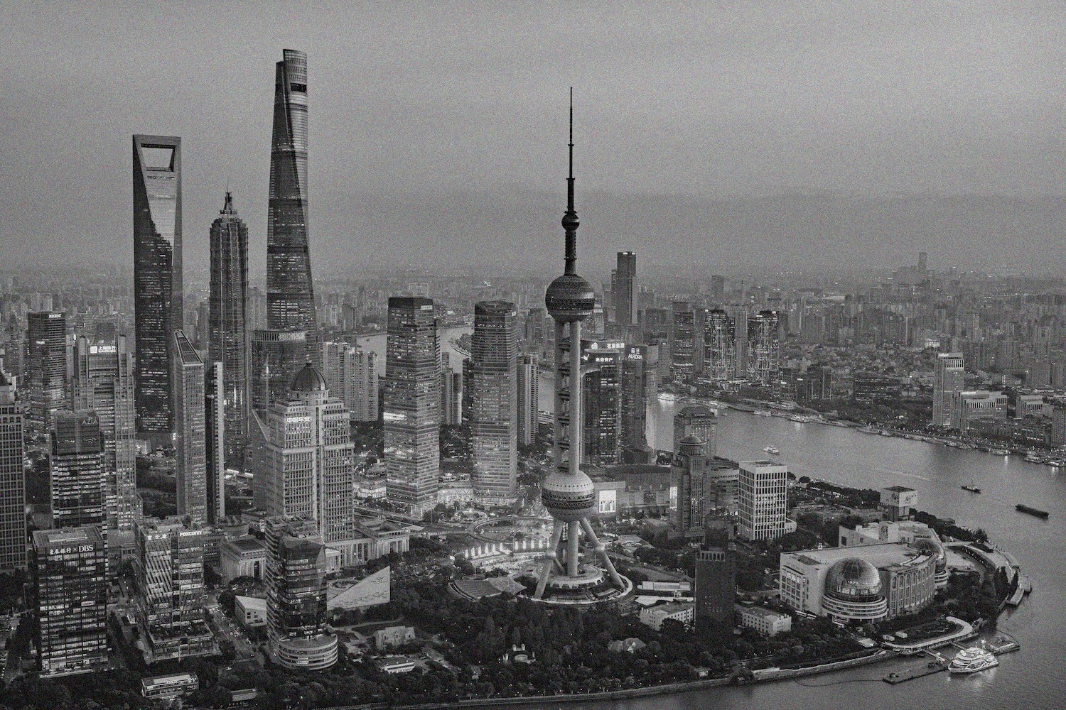 Aerial night view of Shanghai's Lujiazui skyline with the Oriental Pearl Tower, illustrating the EKSIG 2027 host city.